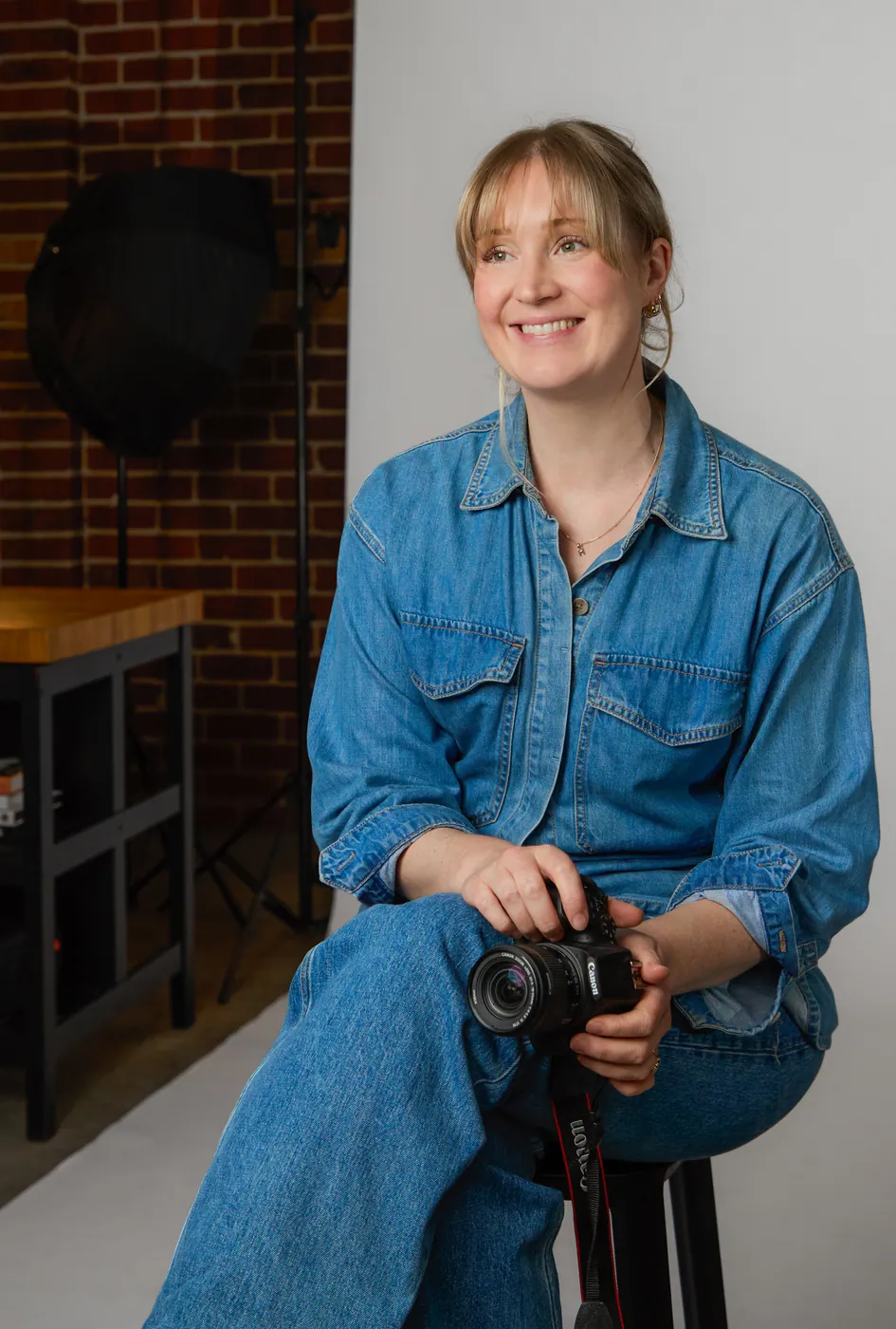 Katie from Peach Cloud Studio seated with a camera